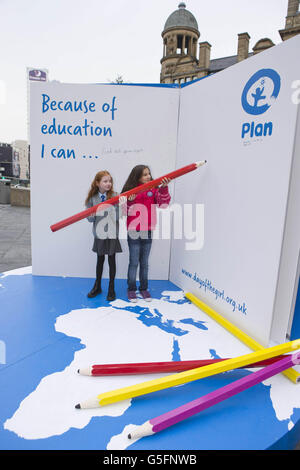 Le studentesse di 10 anni Elisha Kendall di Bolton (a sinistra) e Anastasia Barlow, di Bury (a destra), firmano l'installazione del libro di Plan UK nella piazza di scambio di Manchester per evidenziare l'importanza dell'istruzione per le ragazze di tutto il mondo nella corsa fino alla Giornata Internazionale della ragazza l'11 ottobre. Foto Stock