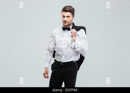 Bel giovane uomo in smoking con papillon tenendo la sua camicia Foto Stock