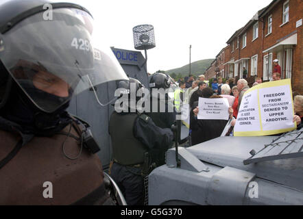 I protestanti residenti della strada Ardoyne protestano dietro un cordone di RUC, tenendo manifesti in aloft mentre manifestano contro gli allievi ed i genitori che fanno il loro modo alla scuola delle ragazze della Santa Croce a Belfast. * i Loyalists hanno fischiato e gridato gli abusi ai genitori dei bambini della scuola primaria della Santa Croce nel nord di Belfast tra gli avvertimenti la protesta potrebbe durare a tempo indeterminato a meno che i colloqui non si mettano in atto per cercare di porre fine allo stand-off. Foto Stock