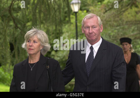 L'ex calciatore e personalità televisiva Bob Wilson (r) e moglie arrivano al servizio commemorativo del leggendario commentatore di calcio Brian Moore alla chiesa di St. Giles a Farnborough, Kent. Foto Stock