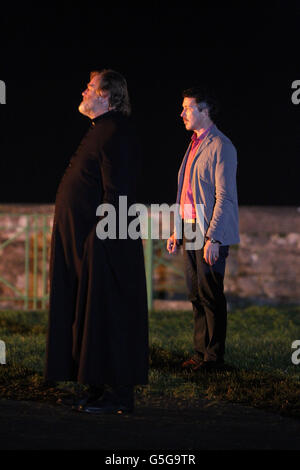 Brendan Gleeson (a sinistra) e Aidan Gillen sul set del nuovo film irlandese 'Calvario' a Rush Co.Dublin, come centinaia di persone locali si sono rivelate a guardare le riprese come una chiesa fittizia è stata bruciata nel villaggio. Foto Stock