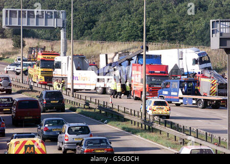 La scena sull'autostrada M11 a seguito di un incidente che ha coinvolto tre automezzi pesanti e quattro vetture. Si credeva che quattro persone fossero morte nell'incidente, tra sei e sette incroci della carreggiata londinese, a sud di Harlow, Essex. Foto Stock