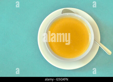 Vista superiore della zuppa servita in una ciotola bianco e la piastra con cucchiaino Foto Stock