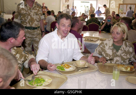 Il primo ministro britannico Tony Blair visita le truppe britanniche in esercizio in Oman. Blair si unì alle truppe di un Mess improvvisato per un pranzo a base di curry, riso e piselli. *...ed è seduto con il Corporal Lynn Stevenson (R) del 30 Signal Regiment basato a Nuneaton e Paul Taylor, normalmente basato a Tidworth, Wiltshire. Blair ha fatto un tour della base di al Shaa'afa, il centro di comando dell'operazione Swift Sword II, che ha coinvolto più di 20,000 militari britannici e donne nel più grande dispiegamento dopo la guerra del Golfo. Foto Stock