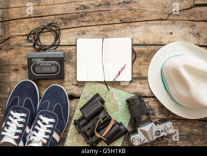 Set di accessori per il viaggio. Scarpe, Telecamera, mappa, notebook su sfondo di legno Foto Stock