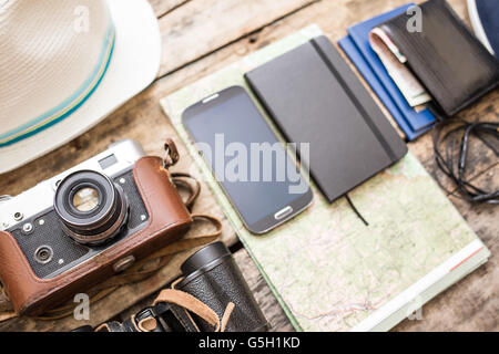 Set di accessori per il viaggio. Scarpe, Telecamera, mappa, notebook su sfondo di legno Foto Stock