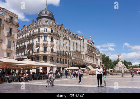 Ciclista locali e turisti alla ricerca di mappa stradale in Place de la Comedie, Montpellier, nel sud della Francia. Foto Stock