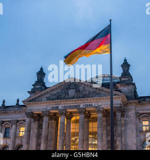 La facciata anteriore del Reichstag a Berlino la notte, la Germania con la bandiera tedesca battenti. Foto Stock