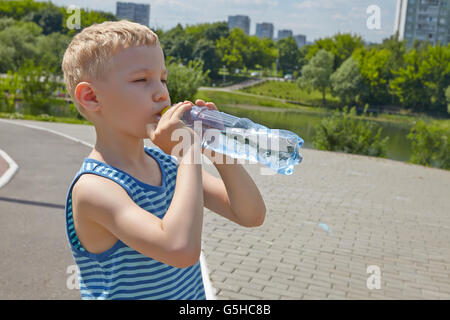 Bambino di bere acqua pura in un parco Foto Stock