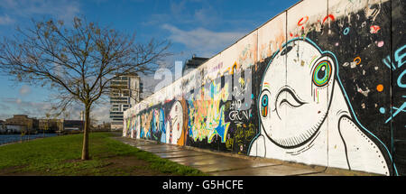 Le sezioni del muro di Berlino, ora coperto di arte di strada presso la East Side Gallery di Berlino, Germania Foto Stock