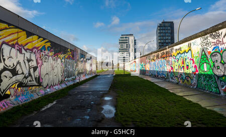 Le sezioni del muro di Berlino, ora coperto di arte di strada presso la East Side Gallery di Berlino, Germania Foto Stock