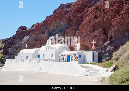 Chiesa a Santorini isola in Grecia, costruita in modo riconoscibile. La spiaggia rossa rocce Foto Stock