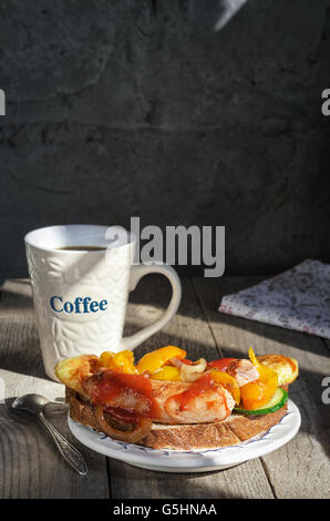 Sandwich con salsicce alla griglia su un piatto e tazza da caffè Foto Stock