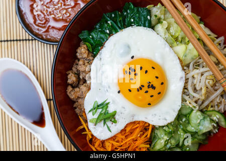 Cucina Coreana, carni bovine Bibimbap in una pentola di creta sul tavolo di legno Foto Stock