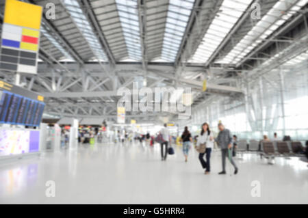 Viaggiatore in airport terminal la sfocatura dello sfondo bokeh di fondo con luce Foto Stock