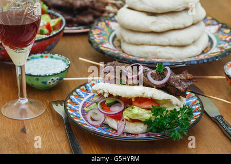 Spiedino di carne con erbe aromatiche, calce e pane pita. Foto Stock