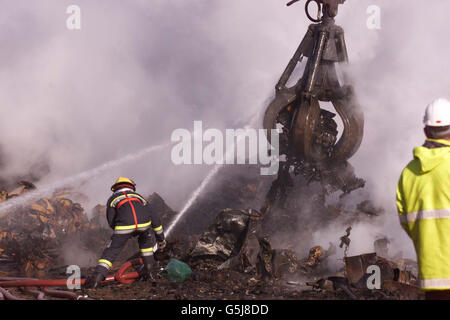 Un vigile del fuoco, uno di più di 110, che stava affrontando una bizzarro in Jordan's Scrap Yard a North Quay, Newhaven, East Sussex, dove almeno 2,000 rottami di automobili stavano bruciando fuori controllo. I vigili del fuoco sono riusciti a circondare l'inferno, ma sono stati impotenti a fermarlo. * i capi di fuoco hanno detto che l'inferno potrebbe continuare per due giorni come parecchie tonnellate di gomma e di plastica lo alimentano. Foto Stock