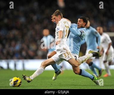 Il ben Davies di Swansea City (a sinistra) e il Carlos Tevez di Manchester City (destra) battaglia per la palla Foto Stock