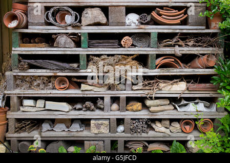 Casa di insetti realizzata utilizzando vecchi pallet in legno per incoraggiare gli insetti (FAUNA) nel giardino. Cotswolds, Inghilterra Foto Stock