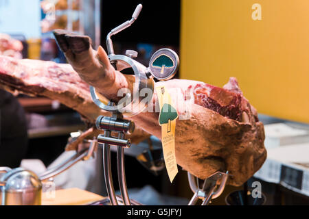 Chiudere orizzontale di un prosciutto iberico in un jamonera a Maiorca. Foto Stock
