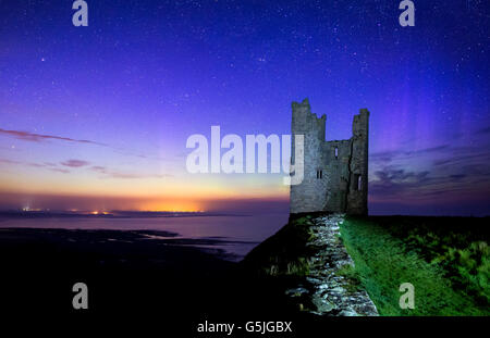 Le luci del nord dietro Lilburn torre/Dunstanburgh Castle, Northumberland Foto Stock