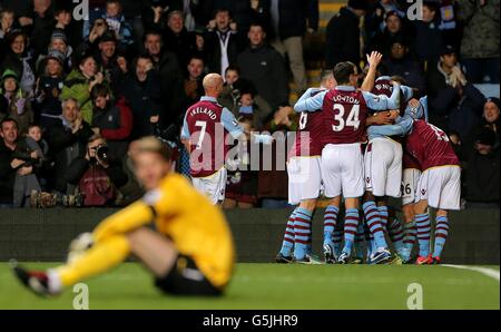 Andreas Weimann di Aston Villa è mollato dai suoi compagni di squadra dopo aver segnato il suo primo gol del gioco, come il portiere del Manchester United David De Gea siede espulso Foto Stock