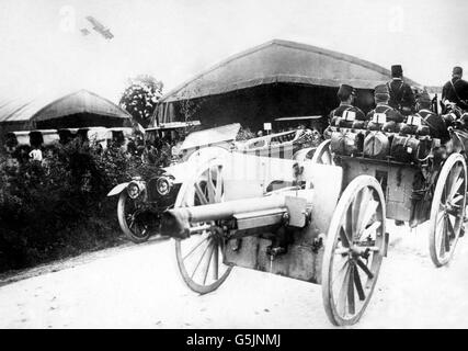 Un cannone francese del 75 che passa attraverso un villaggio in Francia, con un biplano Farman che agisce come scout. Foto Stock