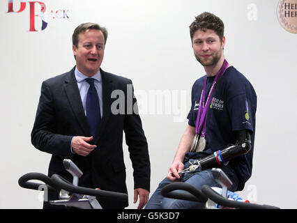 Il primo ministro David Cameron (L) incontra il soldato ferito e Paralympian Jon-Allan Butterworth a Tedworth House, un centro di recupero per gli eroi a Tidworth, Wiltshire. Foto Stock