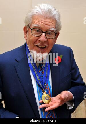 L'emittente australiana Rolf Harris detiene con orgoglio il funzionario dell'Ordine dell'Australia, presentato dall'Alto Commissario John Dauth, nella sede australiana di Londra centrale. Foto Stock