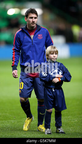 Calcio - UEFA Champions League - Gruppo G - Celtic v Barcellona - Celtic Park. Lionel messi di Barcellona si erge con una giovane mascotte Foto Stock