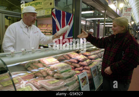 Un acquirente acquista alcune salsicce dallo stand Gee & Son allo Smithfield Market, Londra. Il mercato ospita il Festival Nazionale della carne. Il Royal Smithfield Club ha assegnato trofei allo chef barbecue e al rivenditore di carne dell'anno. *...ci saranno anche le finali di carcasse che presentano i migliori prodotti di bestiame provenienti da tutto il paese, con 375 carcasse di 120 roditori. Foto Stock