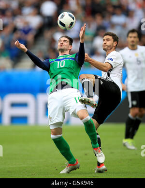 In Irlanda del Nord la Kyle Lafferty (sinistra) e il tedesco Jonas Hector (destra) battaglia per la palla in aria durante UEFA EURO 2016, gruppo C corrispondono al Parc des Princes, Parigi. Foto Stock