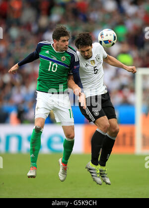 In Irlanda del Nord la Kyle Lafferty (sinistra) e la Germania Mats Hummels battaglia per la palla in aria durante UEFA EURO 2016, gruppo C corrispondono al Parc des Princes, Parigi. Foto Stock