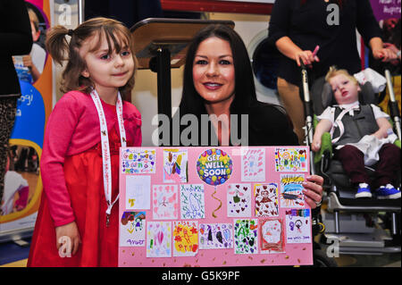 Catherine Zeta Jones presenta una scheda Get-Well-Card a neve Ritchie, 6, da Pontypridd, da tutti i suoi amici nella classe di Miss Armishaw, anno 2, alla scuola elementare di Hwathorn, Pontypridd, dopo aver partecipato a una cerimonia di ridenominazione per Noah's Ark Children's Hospital of Wales, Una struttura specializzata nella capitale gallese di Cardiff e per contribuire a lanciare un'unità di raccolta fondi. Foto Stock