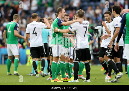 In Irlanda del Nord la Jonny Evans (sinistra) abbraccia la Germania Bastian SCHWEINSTEIGER (destra) dopo la UEFA Euro 2016, gruppo C corrispondono al Parc des Princes, Parigi. Foto Stock