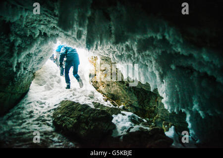 Caucasian escursionisti a piedi nella grotta ghiacciata Foto Stock