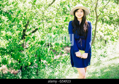Donna cinese in piedi in giardino Foto Stock