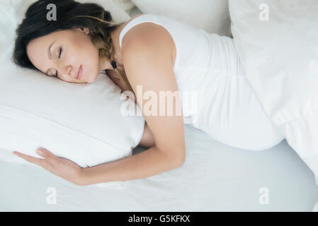 Caucasico incinta donna che dorme nel letto Foto Stock