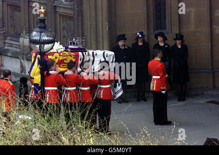 La Regina Elisabetta II della Gran Bretagna si trova con altri membri della famiglia reale alla porta di Westminster Hall, Londra, quando arriva la bara della Regina Elisabetta, la Regina Madre. Sarà in stato fino al funerale presso l'abbazia di Westminster di martedì. Foto Stock