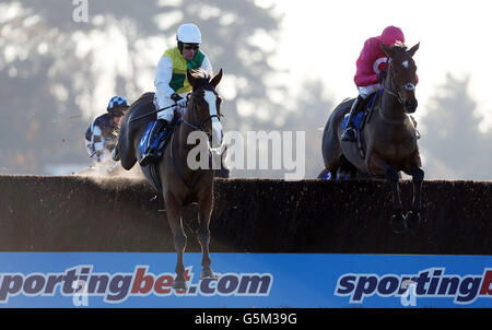 Il vincitore finale Grove Prdie guidato da Andrew Tinkler (a sinistra) salta con Keppols Hill guidato da Ruby Walsh (a destra) sulla loro strada per la vittoria nel Racing Welfare Jonny Brown Novices&acute; Chase durante lo Student Raceday all'Ippodromo di Exeter. Foto Stock