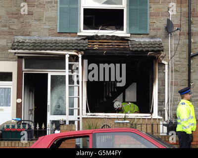 I lavoratori dei servizi di emergenza in una casa di Cossham, Bristol, dopo nove persone sono stati portati in ospedale a seguito di un incendio di casa in cui il cane di famiglia è morto. Foto Stock