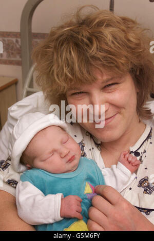 Anne Meier cullerà dolcemente sua figlia Rhea nata alle 12:30 di questa mattina, Capodanno al St Mary's Hospital di Portsmouth, Hampshire. Il personale di sicurezza ha acquistato un orsacchiotto (a sinistra) per celebrare l'occasione del primo bambino dell'ospedale nel 2002. * Rhea non era dovuto per un'altra settimana ed è stato consegnato dalla sezione cesarea. Foto Stock