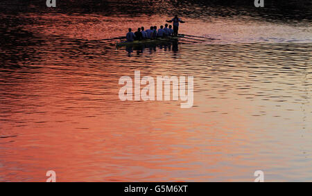 I membri del club di Aberdeen Rowing praticano sul fiume Dee, Aberdeen, mentre il sole tramonta sul fiume. Foto Stock