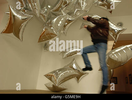 Un visitatore gode del contatto con Silver Clouds, un'opera del 1966, dell'artista americano Andy Warhol in mostra in un retropettivo del suo lavoro al Tate Modern sulla South Bank di Londra. La mostra si apre al pubblico il 7 febbraio. Foto Stock