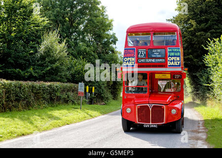 Un ex London Transport double decker bus fa il suo modo attraverso Imber villaggio su Salisbury Plain sul 2015 Imberbus giorno. Foto Stock