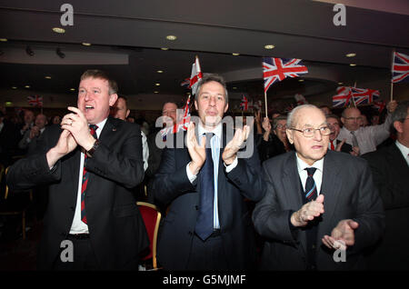Ian Paisley Jnr MP, (centro) con i colleghi del partito applaude Peter Robinson DUP leader e Northern Ireland First Minister alla conferenza annuale del partito, presso l'hotel la Mon House fuori Belfast. Foto Stock