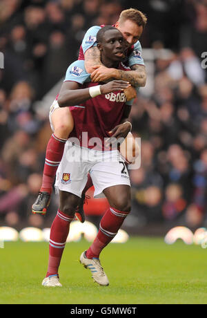 Mohamed DIAME (in piedi) di West Ham United celebra il secondo gol del suo fianco con il compagno di squadra Matt Taylor durante la partita Barclays Premier League a Upton Park, Londra. Foto Stock