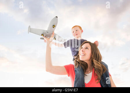 Caucasian madre e figlio battenti aeroplano giocattolo Foto Stock