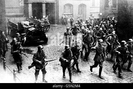 BERLINO 1919: Le truppe del governo tedesco, sostenute dall'artiglieria, avanzano durante gli sporadici combattimenti con gli spartacisti socialisti nella capitale tedesca, Berlino, nel 1919. Le tre strisce di materiale su alcune delle maniche uniformi indicano gli ex guardiani. Foto Stock