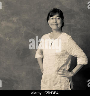 Donna Giapponese sorridente con le mani sui fianchi Foto Stock